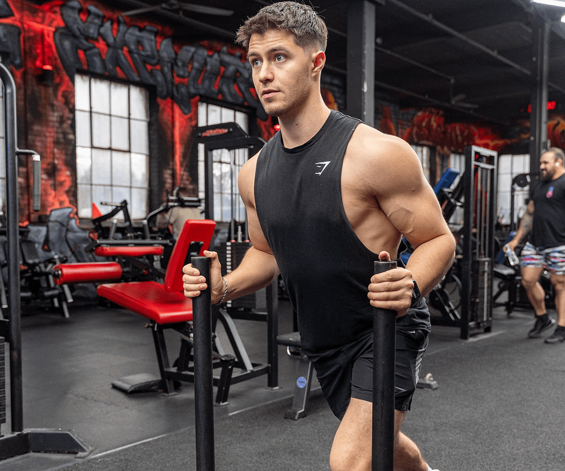 A man working out with resistance bands in a gym.
